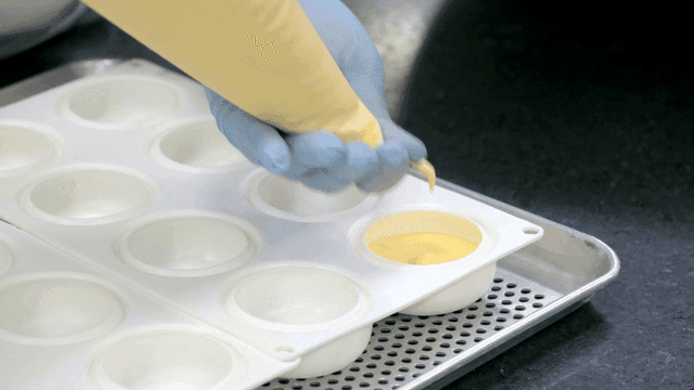 Filling molds with batter using a piping bag