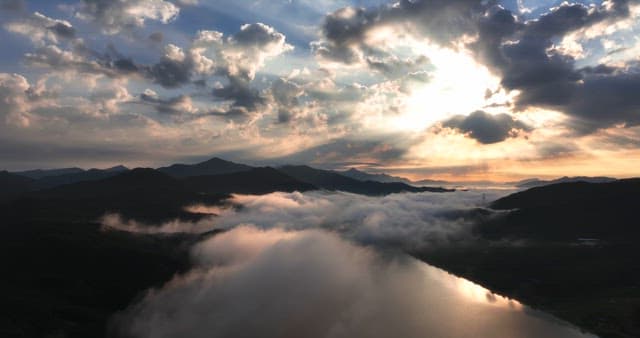 산 위 구름 사이로 비치는 햇빛