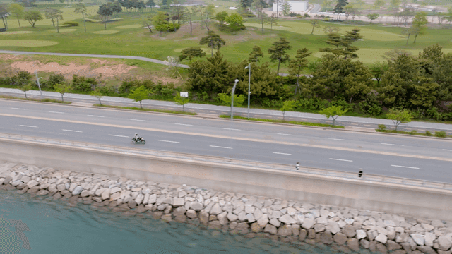 해안 도로를 달리는 오토바이 운전자