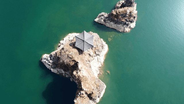 Small rock with pavilion in lake