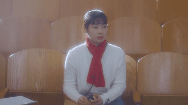 Woman sitting in empty theater seats