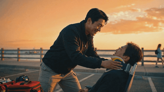 Paramedic assisting a patient by the sea at sunset
