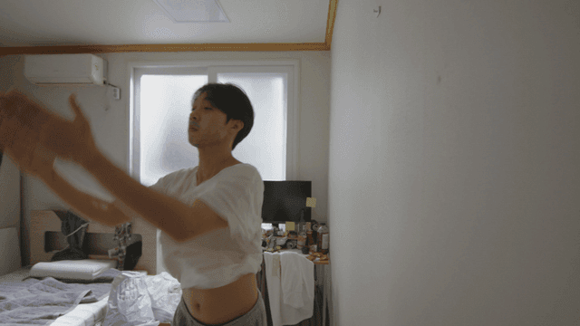 어수선한 방에서 벌레를 잡고 있는 남자