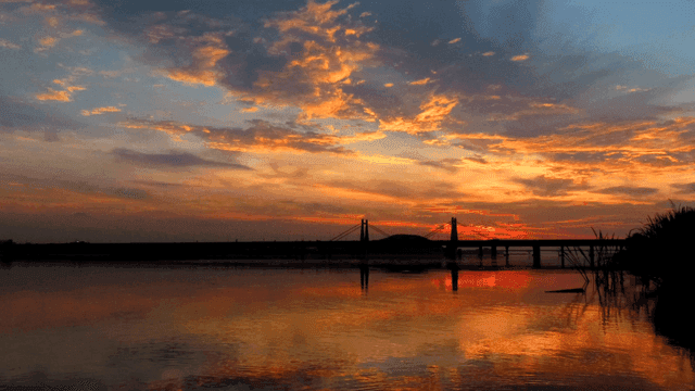 Bridge over river at sunset