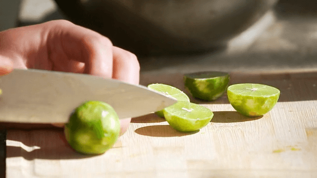 나무 도마 위에 라임을 자르는 모습