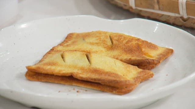 Freshly baked crispy apple pies served on a white plate