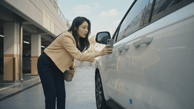 Woman taking photos of damaged car in parking lot