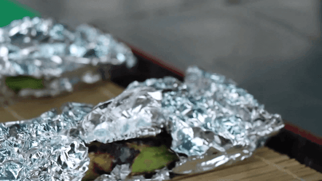 호일에 싸인 구운 채소를 준비하는 손