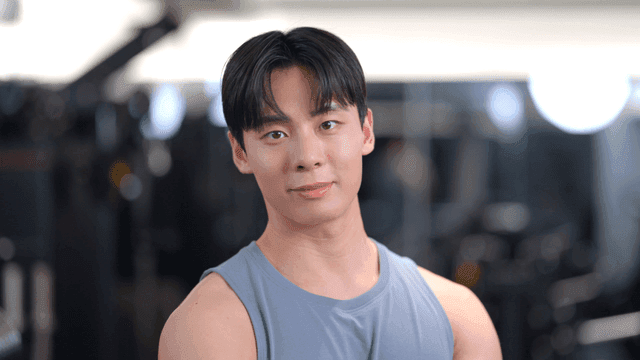 헬스장에서 정면을 보고 자신감 있게 포즈를 취하는 젊은 남성