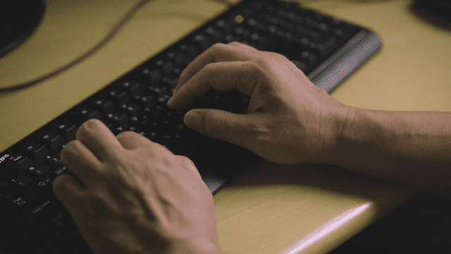 Hands typing on a keyboard