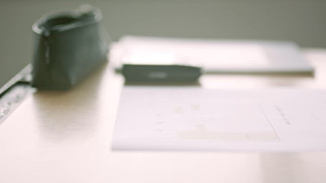 Student Answering Phone While Writing at Desk
