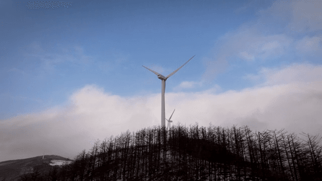 눈 덮인 언덕 위의 풍력 터빈