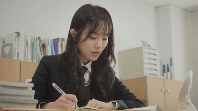 Schoolgirl with long wavy hair solving problems in the classroom