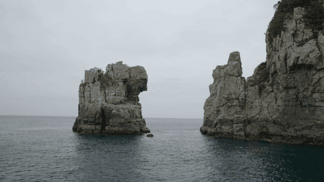 Rock formations by the sea under a cloudy sky