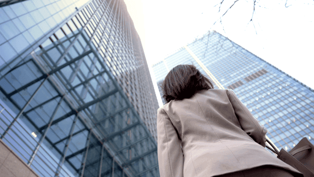 Woman in suit in front of high-rise building