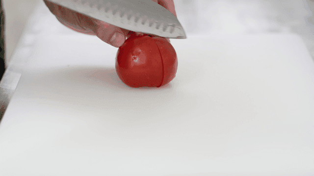 도마 위에서 신선한 토마토 자르기