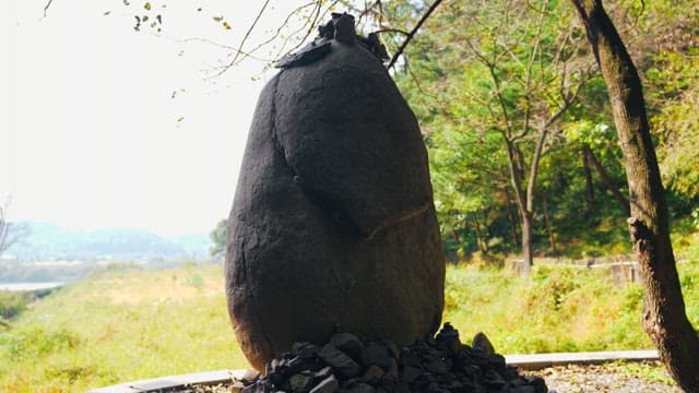 돌탑을 둘러싸고있는 무성한 나무와 녹지