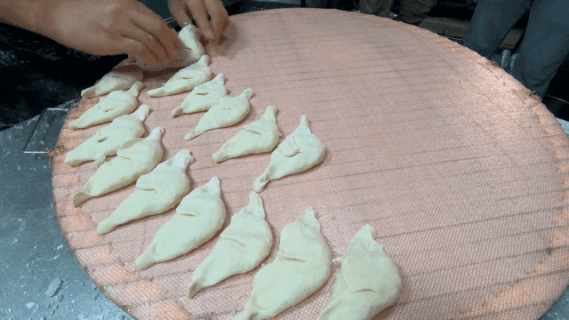 쟁반 위 빠르게 빚어지는 만두들