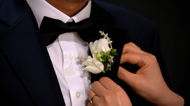 Adjusting a boutonniere on a suit