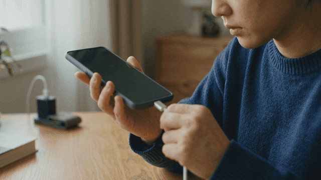 Person connecting a charger to a smartphone