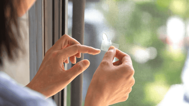 Hands that repair house window screens
