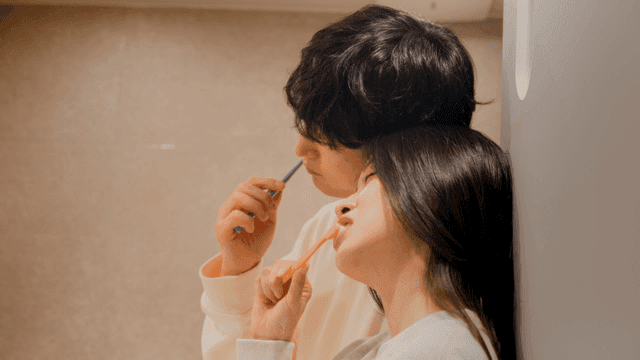 Couple brushing teeth together in bathroom