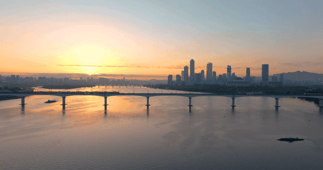 고층 빌딩들이 있는 도시 전경 위 노을