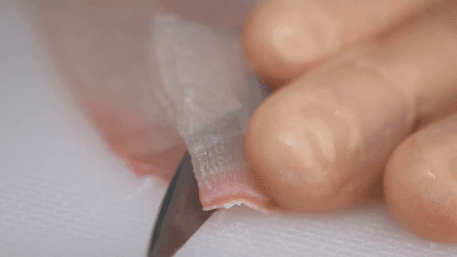 Hands that finely slice fresh fish fillets