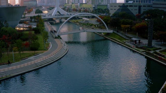 아치 교량이 보이는 도심 공원의 평화로운 일몰