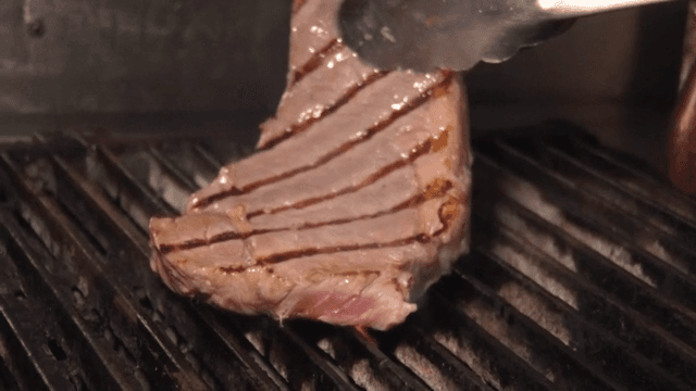 뜨거운 그릴에서 스테이크 굽기