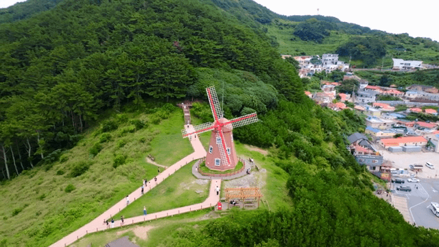 Windmill and village surrounded by greenery