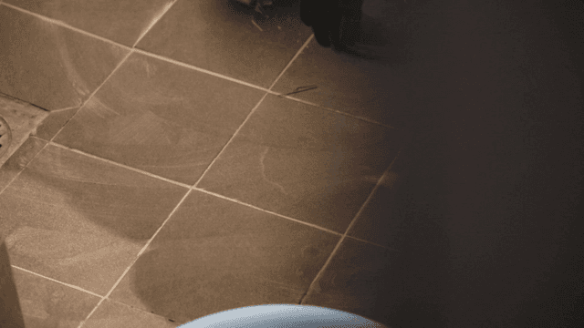 Worker cleaning tiles in a bathroom