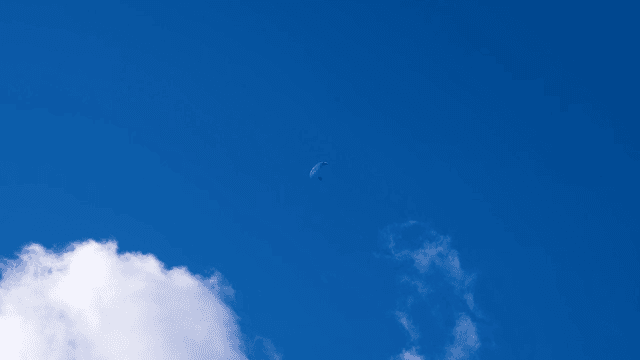 Paraglider soaring in the blue sky