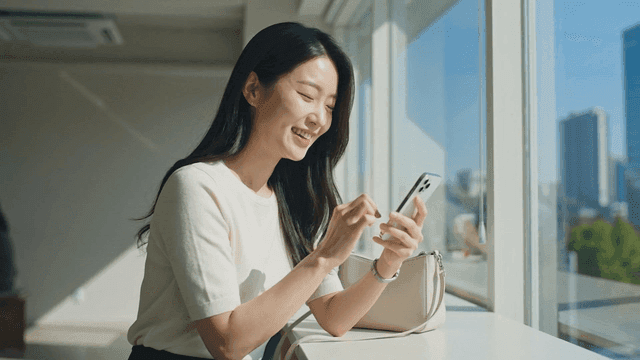 Woman smiling while using smartphone