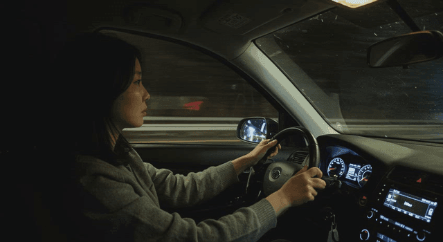 A woman driving a car at night