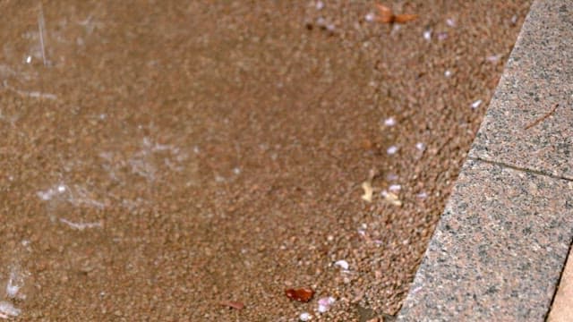 Puddles on wet ground on a cement floor on a rainy day