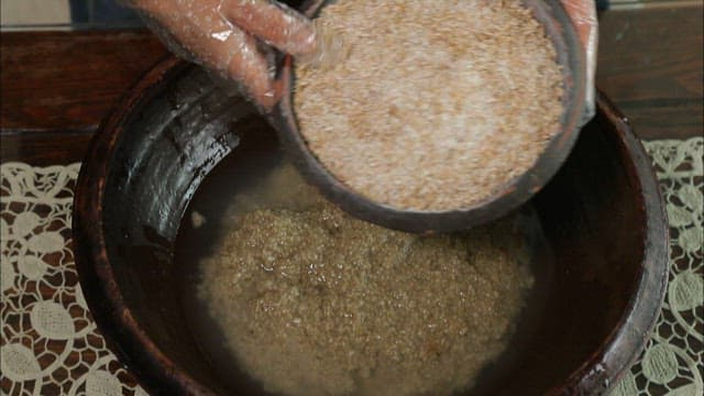 Pouring yeast made by fermenting grains into a traditional jar