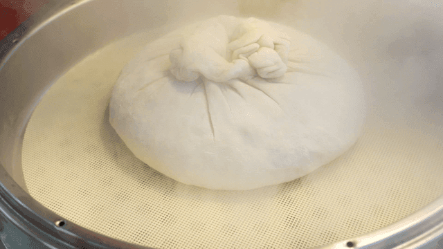 Large dumplings placed in steaming pot
