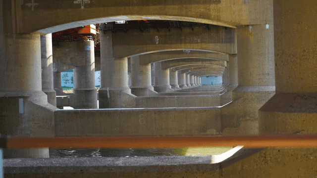 River flowing under large concrete bridge