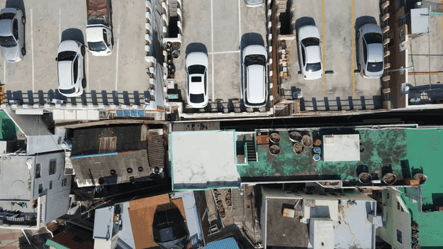 Aerial view of a city parking lot and rooftops