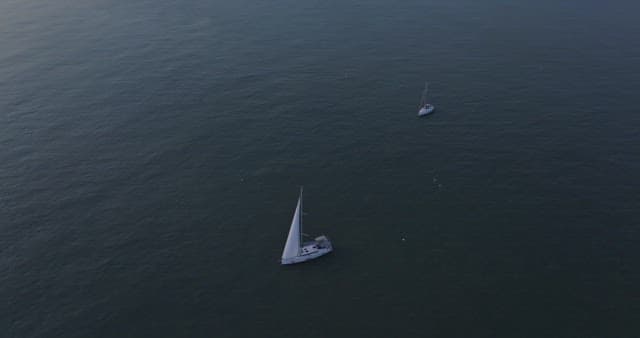 일몰에 잔잔한 바다 위의 요트