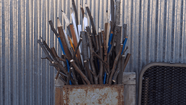 금속 판넬 배경의 나뭇가지 연필 조각품