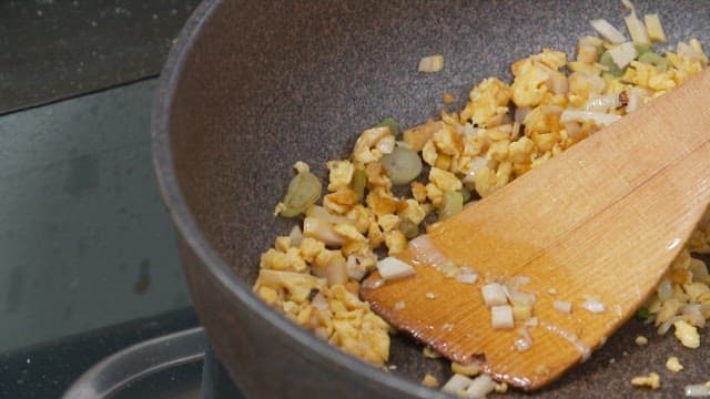 Cooking fried rice with vegetables and eggs in frying pan