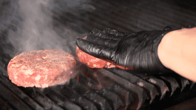 Beef patty grilling on hot grill
