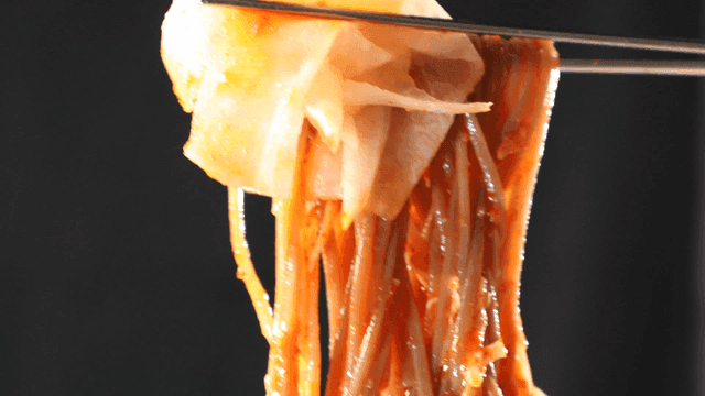 Pickled radish picked with chopsticks and spicy mixed noodles