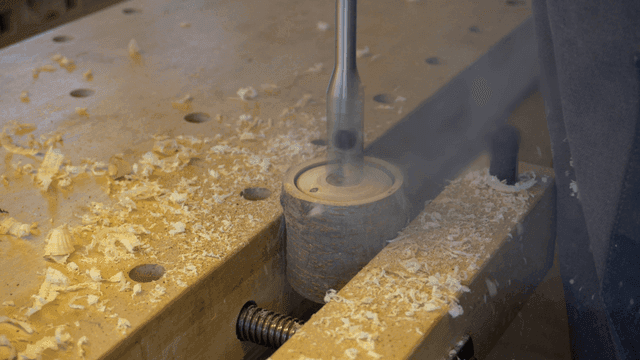 작업대에서 나무를 전동 드릴로 구멍을 뚫는 작업