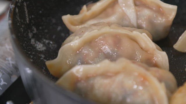 Cooking dumplings in a heated frying pan