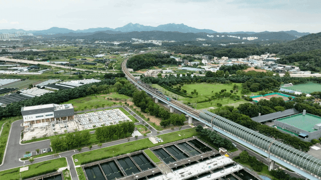 Train running on railway running over greenery