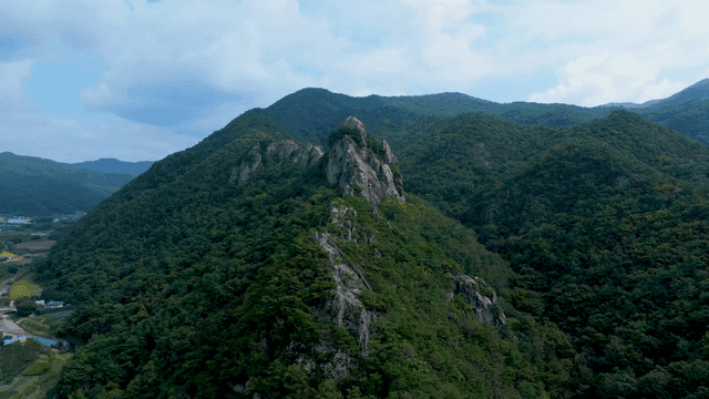 구름 낀 하늘 아래 푸른 산