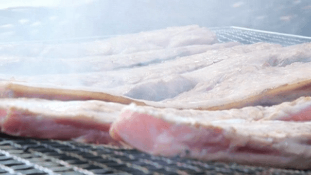 Pork belly grilling on a barbecue